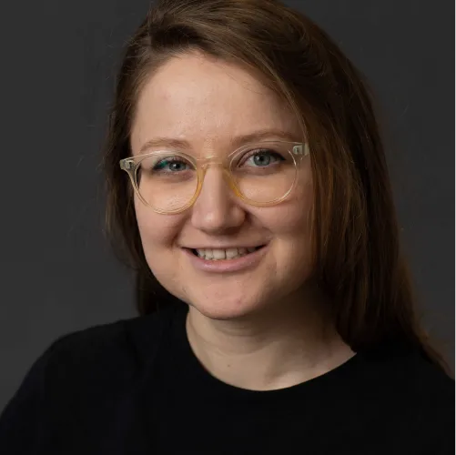 A portrait of Laura Lascau: she is looking directly at the camera with a smile, wearing glasses.